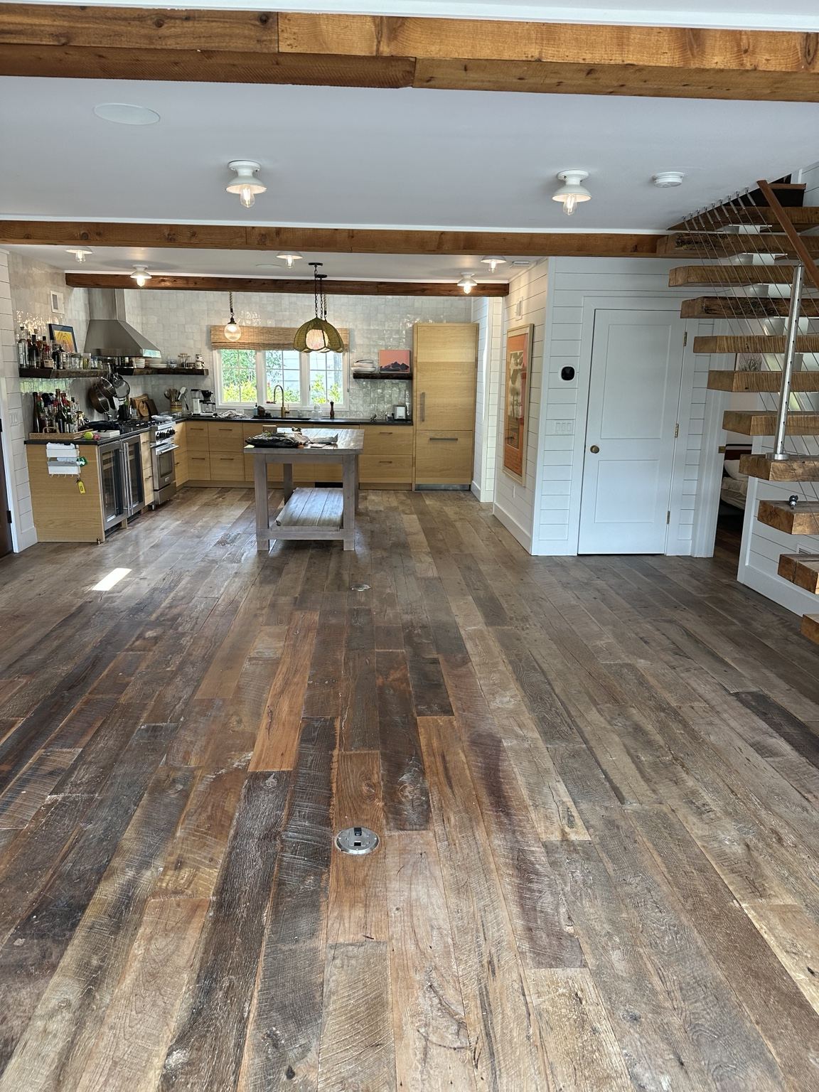 Varied-tone plank floor in a kitchen with exposed wood beams